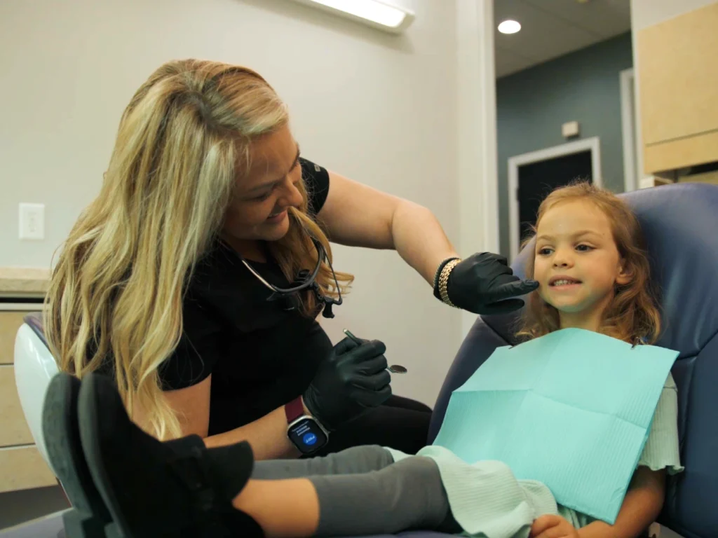 Dental staff treating a smiling child in the dental chair | Locally-owned dentist in Wilmington, NC