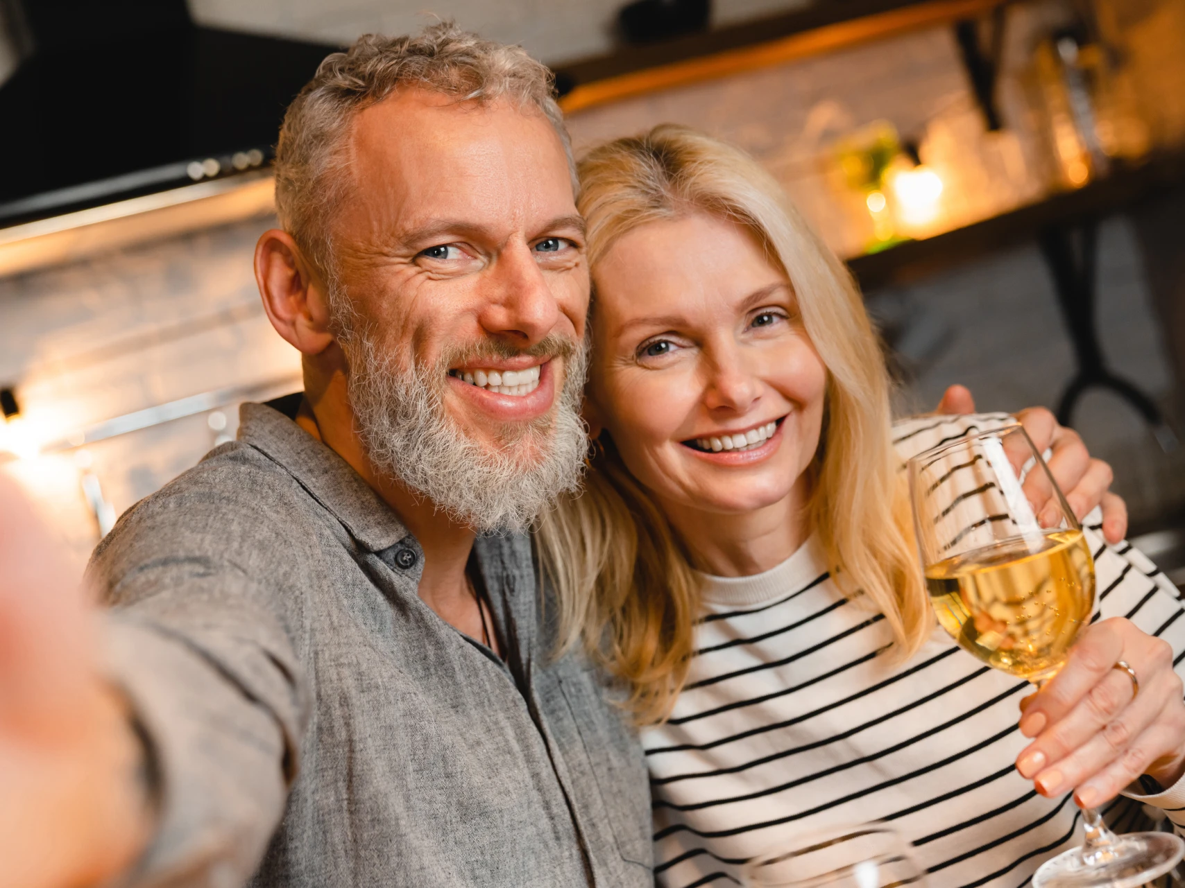 Middle-aged couple smiling with perfect teeth after cosmetic dentistry in Wilmington, NC at Porters Neck Dental Aesthetics.