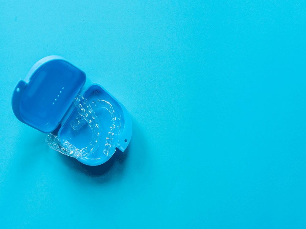 Blue clear aligners case over a blue background.